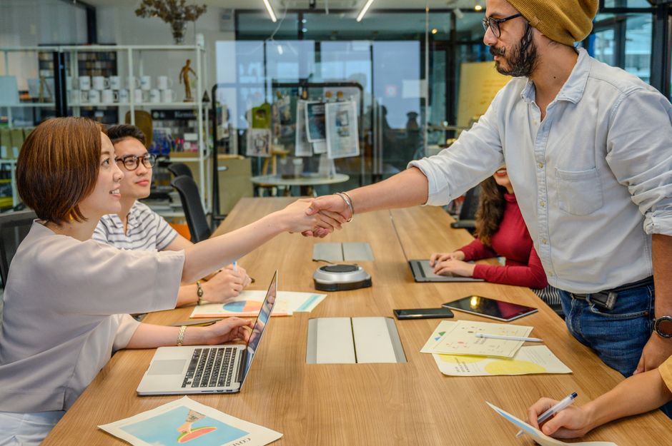 Profesionales estrechando la mano en una reunión de trabajo