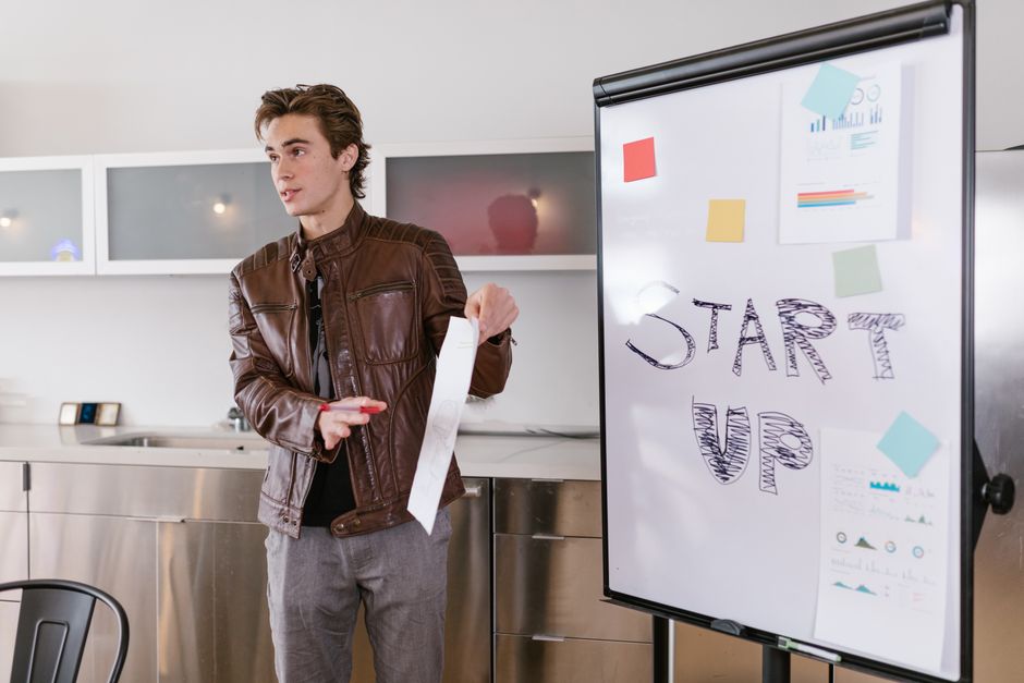Joven emprendedor presentando estrategias de startup con un rotafolio